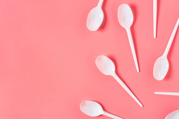 istock White disposable spoons scattered on pink background. Concept of save environment, ecology, recreation on picnic, party and other events. Copy space. Top view 1212380417