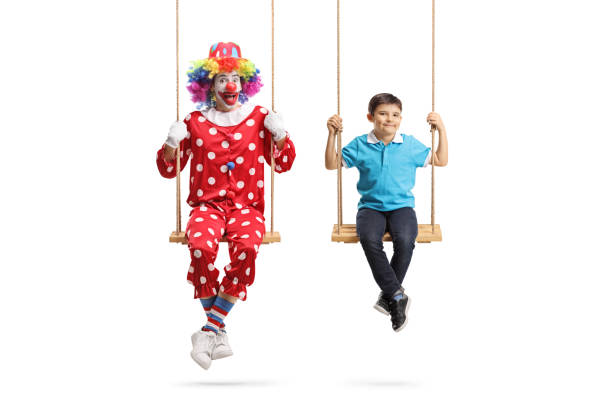 istock Clown and a boy swinging on swings 1212380744