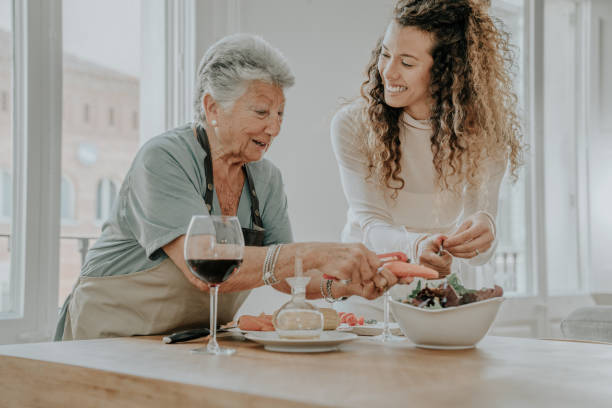 mother and daughter preparing a salad - grandmother senior adult child multi generation family imagens e fotografias de stock