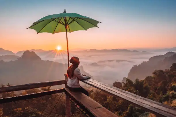 Photo of Happy Woman Enjoying Freedom on top of The morning mist Thailand mountains covered with fog sunrise time Mae Hong Son, Thailand