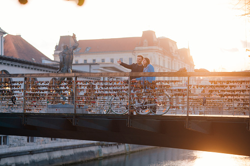 Happy couple in love standing on a bridge over a river in old european town.