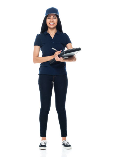 Latin american and hispanic ethnicity female manual worker standing in front of white background wearing baseball cap and holding clipboard Full length of aged 20-29 years old who is beautiful with black hair latin american and hispanic ethnicity female manual worker standing in front of white background wearing baseball cap who is happy who is delivering and holding clipboard woman wearing baseball cap stock pictures, royalty-free photos & images