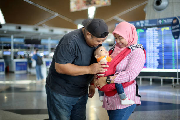 South East Asia: At The Airport Portrait of Muslim male adult with his wife and baby boy at Malaysia airport. klia airport stock pictures, royalty-free photos & images