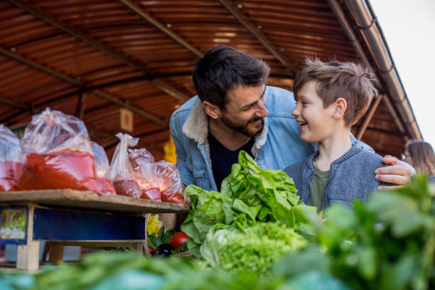 istock Man shopping for vegetables with is child 1212388630