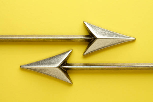 Two arrows on a yellow background point in opposite direction.
