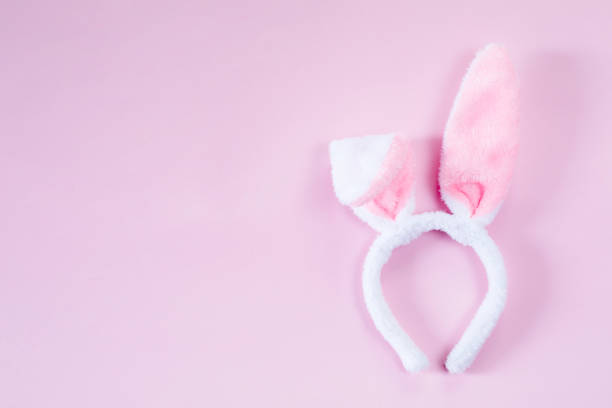 istock pink bunny ears over wooden table 1212389616