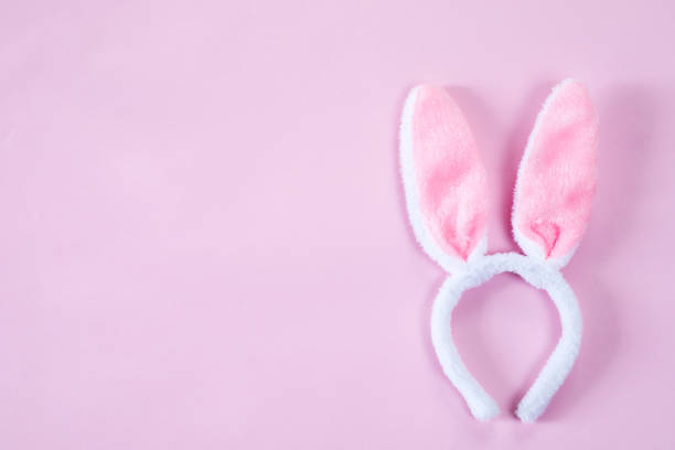 istock pink bunny ears over wooden table 1212389793