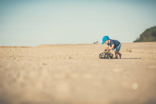 istock Toddler boy playing on a sunny beach 1212390393