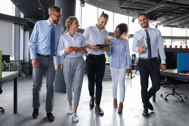 istock Modern business people discussing business and smiling while walking through the office corridor 1212392822