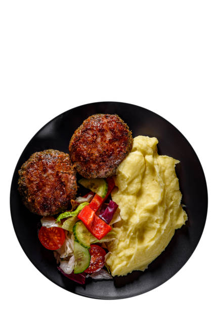흰색 배경에 고립 된 검은 접시에 으깬 감자와 야채 샐러드와 햄버거. 복사 공간이 있습니다. 맨 위 보기 - schnitzel cutlet meat isolated on white 뉴스 사진 이미지