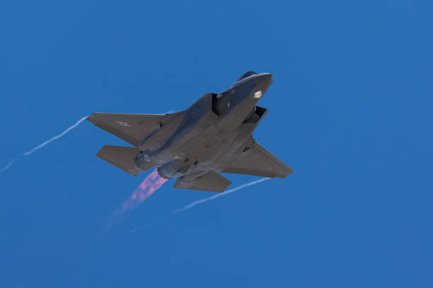 istock F-35 Lightning II  approaching  with afterburner on and condensation trails at the wings tip 1212394629