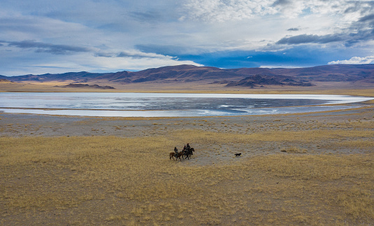 Aerial view of group of eagle hunters near the river in Mongolia