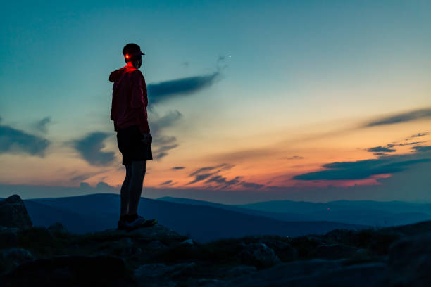 istock Trail runner with head lamp on top of mountain peak at night. 1212395899