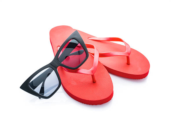 istock Red flip flops and sunglasses isolated on white background 1212397330
