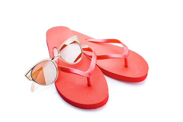 istock Red flip flops and sunglasses isolated on white background 1212397332