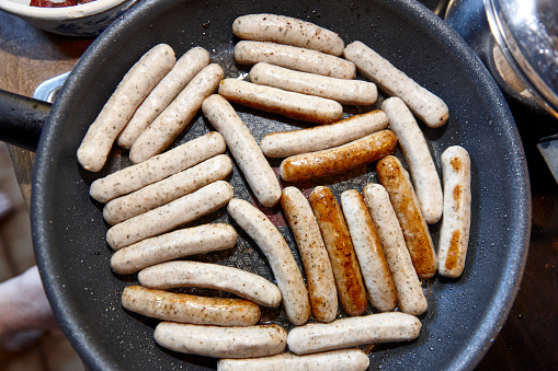 Raw nuremberg sausages in a frying pan