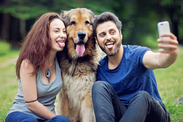 istock Young couple is taking selfie/making video call with their dog 1212402703