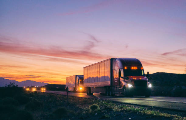 Long Haul Semi Truck On a Rural Western USA Interstate Highway Large semi truck hauling freight on the open highway in the western USA under an evening sky. truck stock pictures, royalty-free photos & images