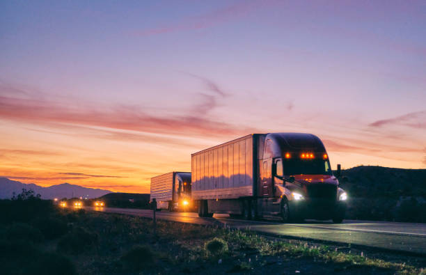 Long Haul Semi Truck On a Rural Western USA Interstate Highway Large semi truck hauling freight on the open highway in the western USA under an evening sky. semi truck stock pictures, royalty-free photos & images