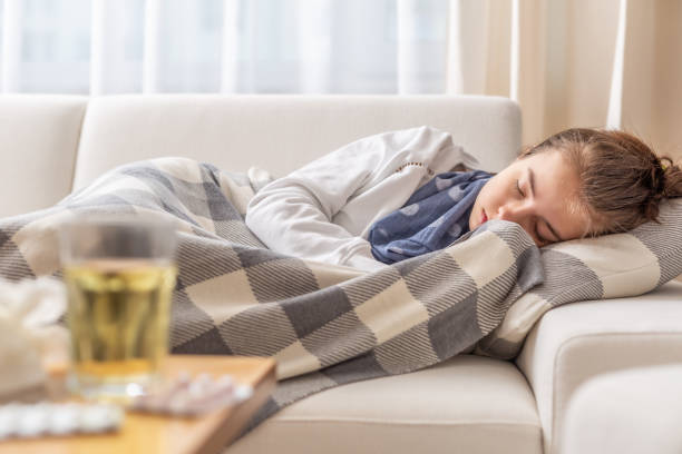 istock Sleeping young sick girl with cold and high fever lying on a sofa. 1212406001