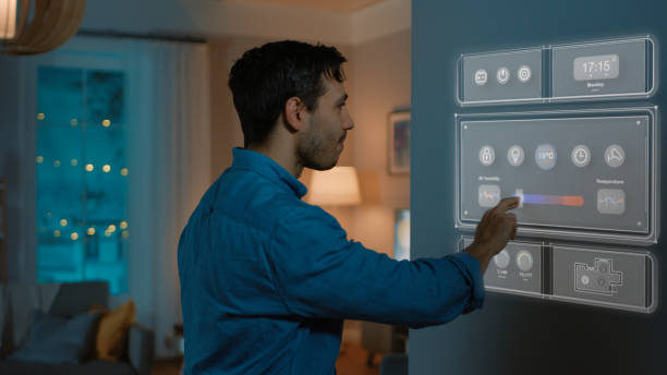 istock Handsome Young Man Walks Over to a Refrigerator. He is Changing Temperature on Smart Fridge Screen at Home. Cozy Kitchen Evening. 1212406134
