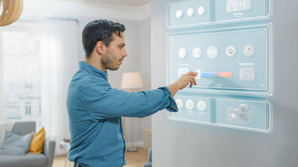istock Handsome Young Man Walks Over to a Refrigerator. He is Changing Temperature on Smart Fridge Screen at Home. Kitchen is Bright and Cozy. 1212406137