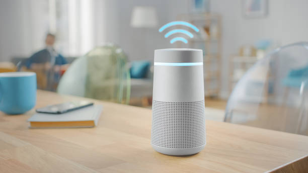 istock Shot of a Smart Speaker with Artificial Intelligence Assistant with Wi-Fi Symbol Standing on the Table in Bright Cozy Living Room. 1212406188