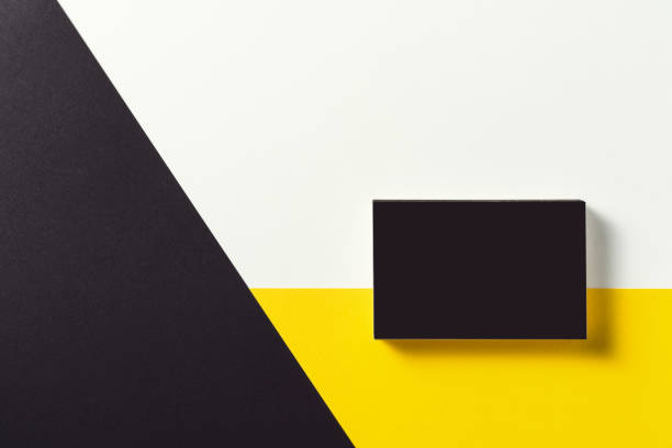 istock Black business card on black, yellow and white background. 1212407179