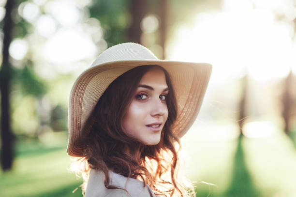 Portrait romantic woman in hat outdoors. Soft colors.