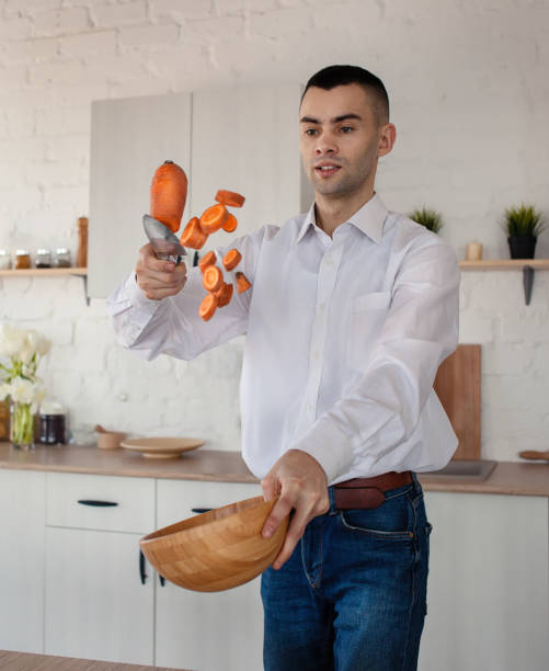 A man cuts carrots in the air on the fly