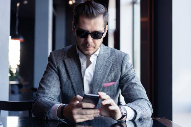 istock Modern businessman drinking espresso coffee in the cafe during lunch time and using mobile phone. 1212410945