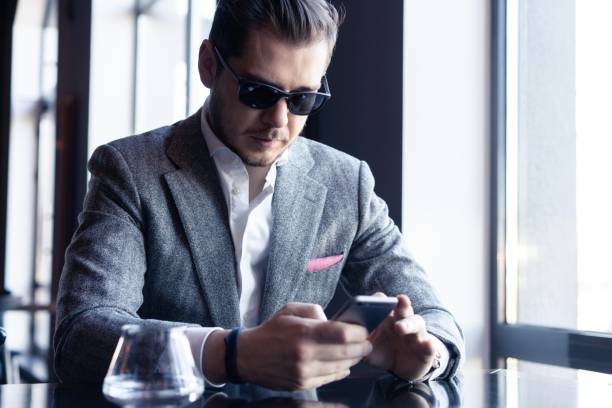 istock Modern businessman drinking espresso coffee in the cafe during lunch time and using mobile phone. 1212410947