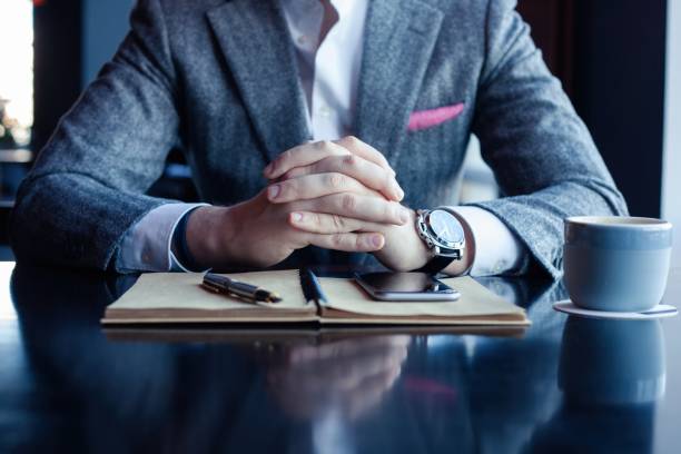 istock Man hand with pen writing on notebook on table. Man working at coffee shop. 1212412535