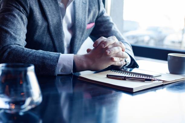 istock Man hand with pen writing on notebook on table. Man working at coffee shop. 1212412540