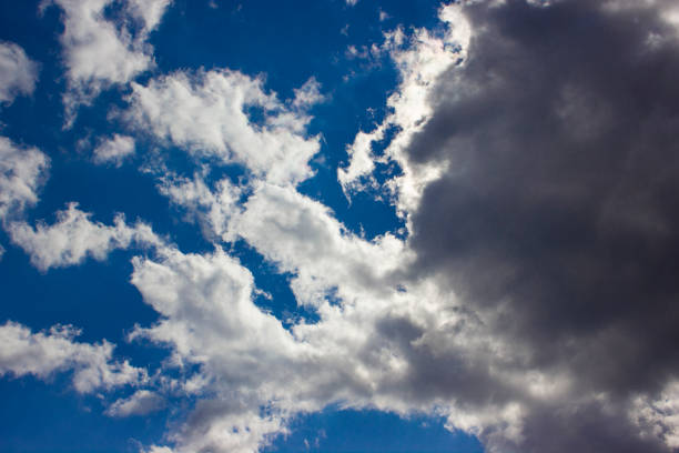 istock Sun behind dark clouds against blue beautiful sky background. 1212413591