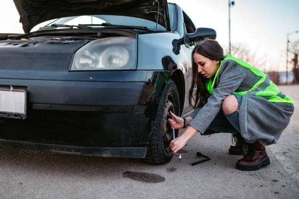 istock Woman changing tire on street 1212414947