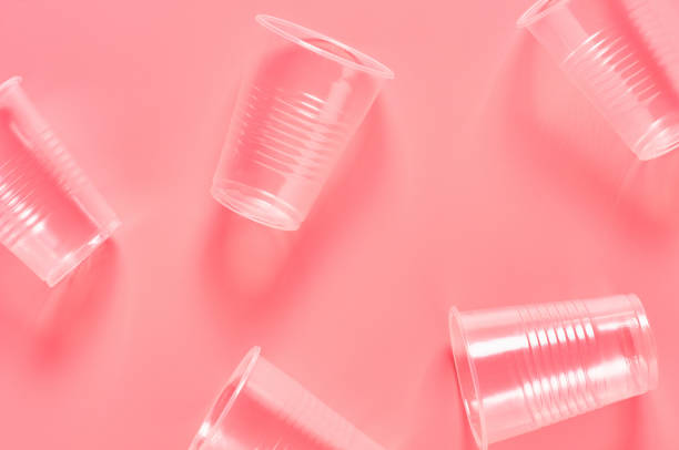 istock Disposable plastic glasses scattered on pink background. Concept of save environment, ecology, recreation on picnic, party and other events. Top view 1212416992