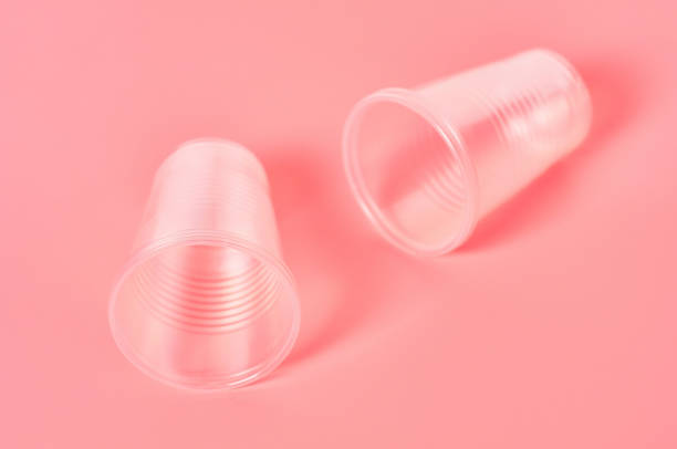 istock Disposable plastic glasses scattered on pink background. Concept of save environment, ecology, recreation on picnic, party and other events 1212416996