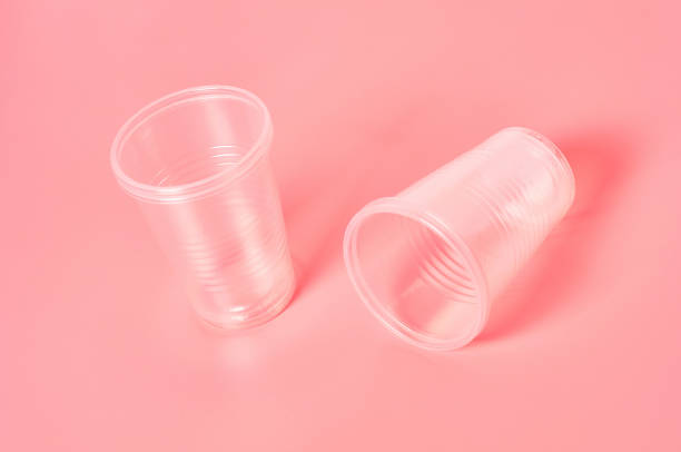 istock Disposable plastic glasses scattered on pink background. Concept of save environment, ecology, recreation on picnic, party and other events 1212417004