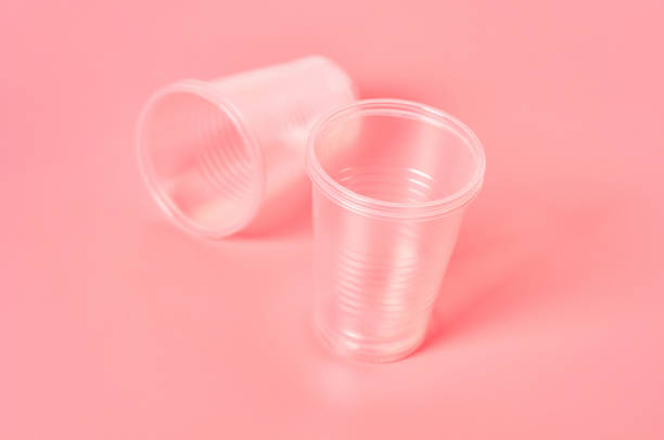 istock Disposable plastic glasses scattered on pink background. Concept of save environment, ecology, recreation on picnic, party and other events 1212417013