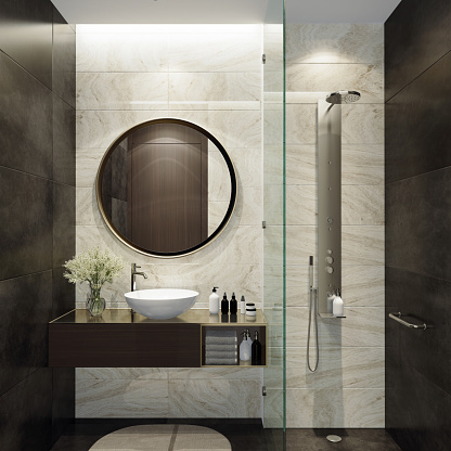 Luxurious bathroom with natural black stone tiles and white stone tiles. Round mirror. Small bathroom.