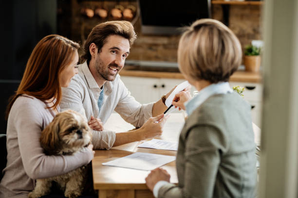 istock Happy couple communicating with insurance agent while having a meeting at home. 1212422689