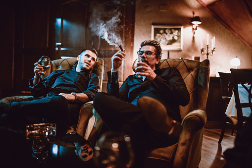 Mafia Family Father And Son Enjoying Good Cognac With Cigars And Conversation