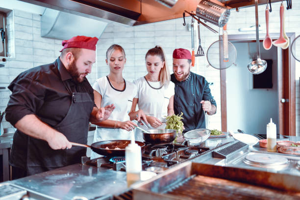 istock Head Chef Explaining To His Team How To Make Perfect Sauce 1212426443