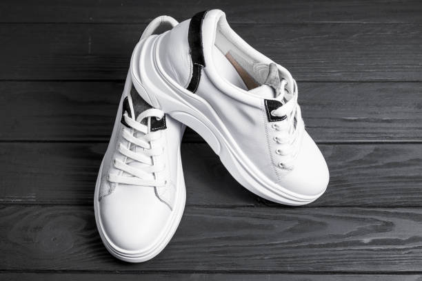 istock New white sneakers isolated on dark background 1212426611