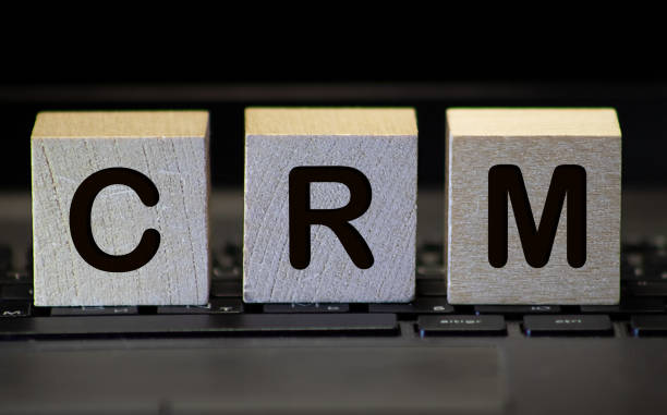 istock CRM (Customer Relationship Marketing) written on a wooden cube in front of a laptop 1212432438
