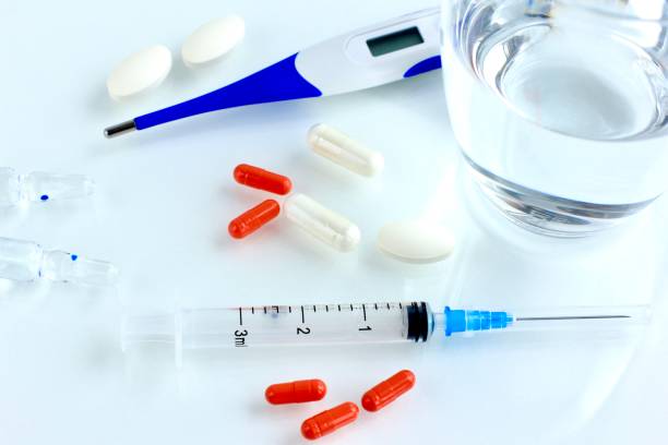 istock Multicolored pills, tablets against the virus, flu, disease, a thermometer and a syringe on light background. Medical concept of Virus Pandemic Protection, Coronavirus COVID-19. 1212435370