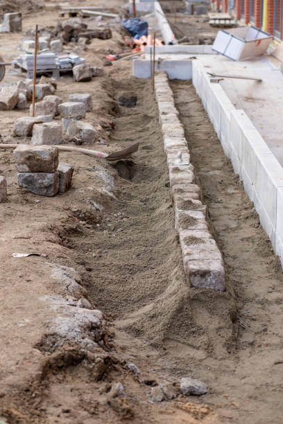 istock Construction site, crafts, road construction, pavement. Laying granite cubes on concrete 1212438399