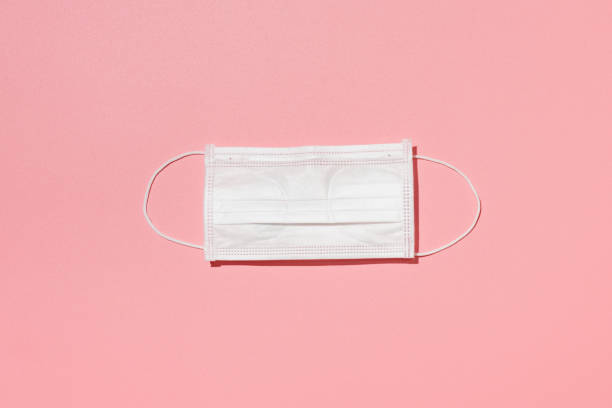 Face pollution mask against a pink background