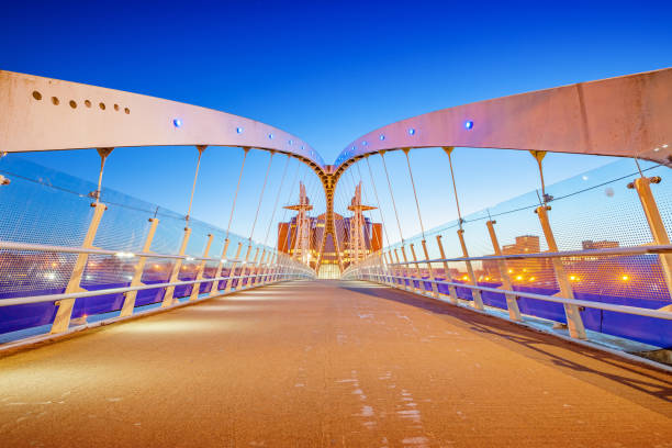 The Millenium Bridge in Manchester England UK illuminated at twilight blue hour.